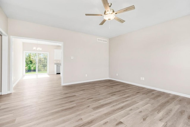 unfurnished room featuring light hardwood / wood-style floors and ceiling fan with notable chandelier