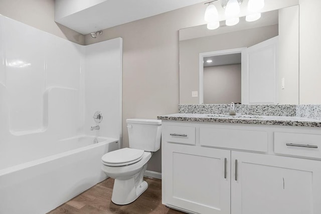 full bathroom with toilet, hardwood / wood-style flooring, shower / bath combination, and vanity