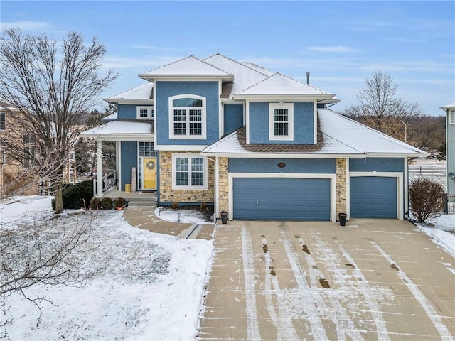 view of front of house featuring driveway, stone siding, an attached garage, and stucco siding