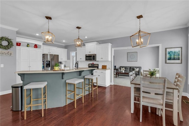 kitchen with stainless steel appliances, dark wood-type flooring, a kitchen breakfast bar, white cabinets, and backsplash