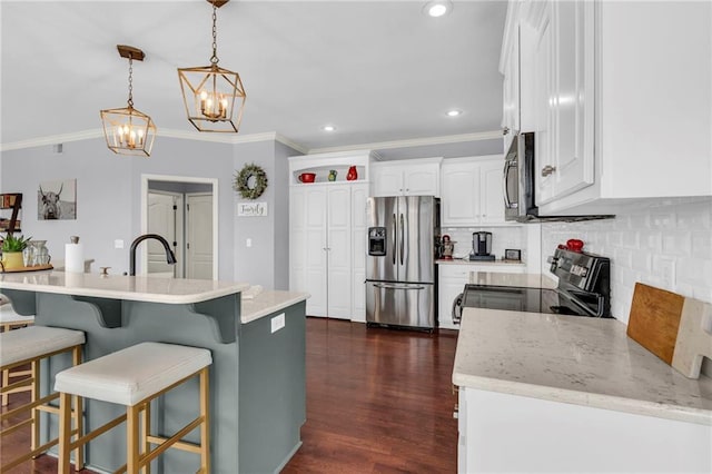 kitchen with stainless steel appliances, tasteful backsplash, dark wood-type flooring, white cabinetry, and a kitchen breakfast bar