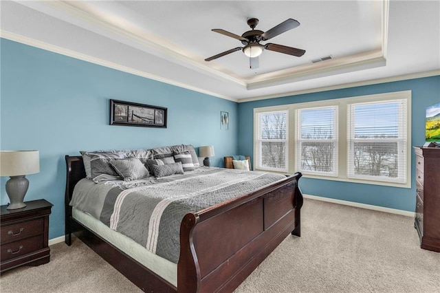 carpeted bedroom with ornamental molding, a tray ceiling, visible vents, and baseboards