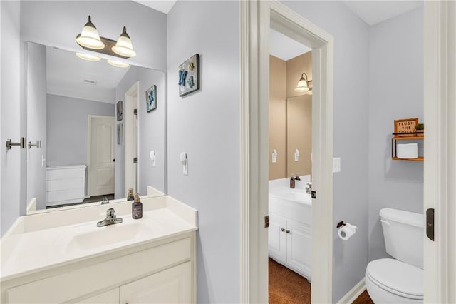 half bathroom with toilet, vanity, and baseboards