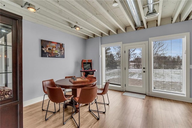 dining space featuring light wood-type flooring, a healthy amount of sunlight, and baseboards