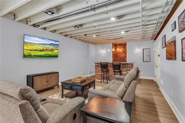 interior space with a dry bar, wood finished floors, and baseboards