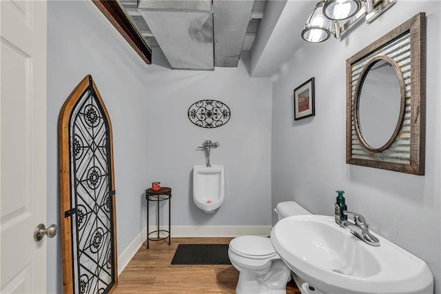 half bathroom with wood finished floors, a sink, toilet, and baseboards