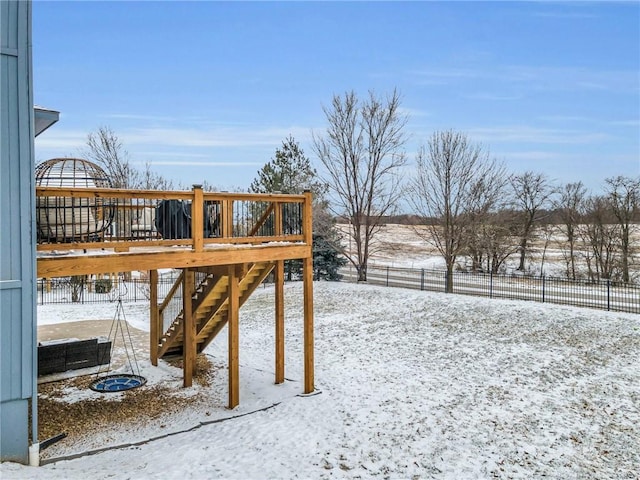 snowy yard featuring fence, stairway, and a wooden deck