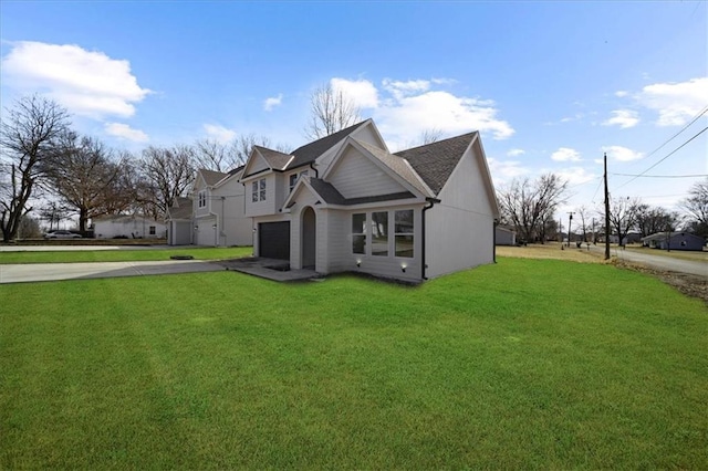 exterior space with a garage, a front lawn, and aphalt driveway