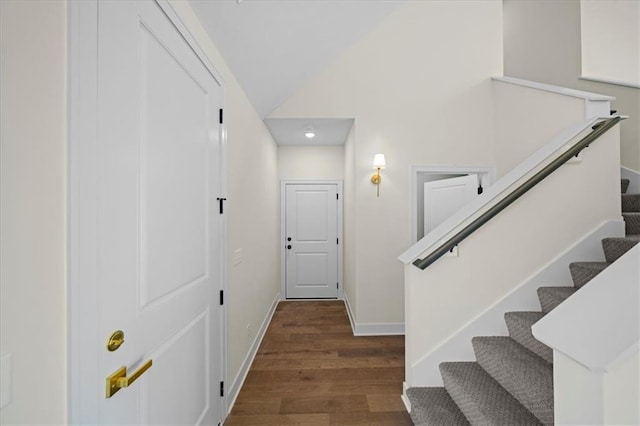 interior space featuring lofted ceiling, baseboards, and wood finished floors