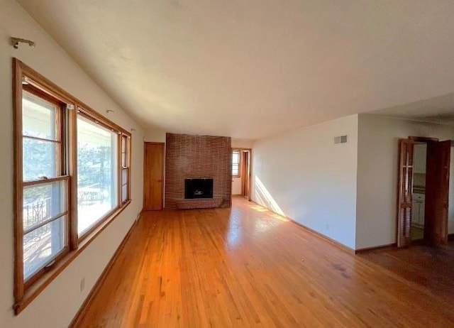 unfurnished living room featuring a fireplace and light hardwood / wood-style flooring