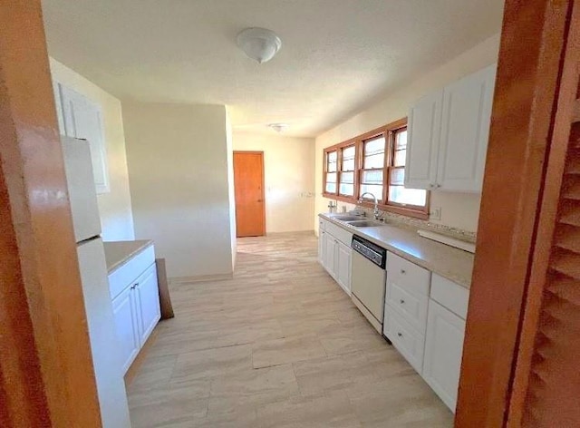 kitchen with sink, dishwasher, and white cabinetry