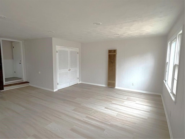 unfurnished bedroom with light hardwood / wood-style floors and a closet