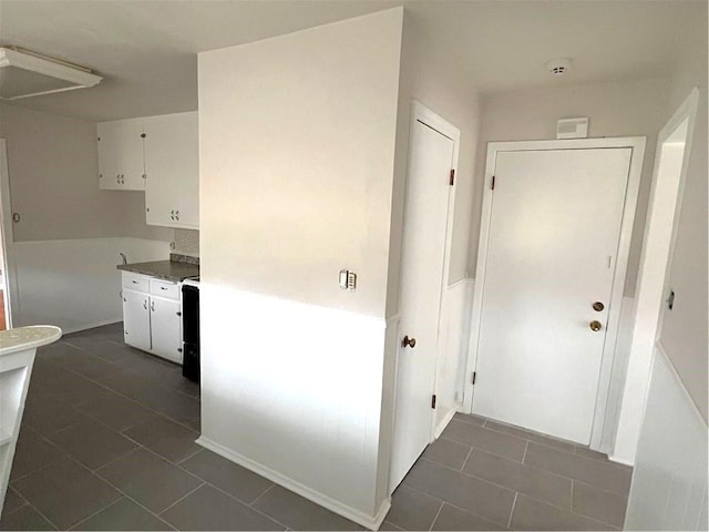 hall featuring dark tile patterned flooring