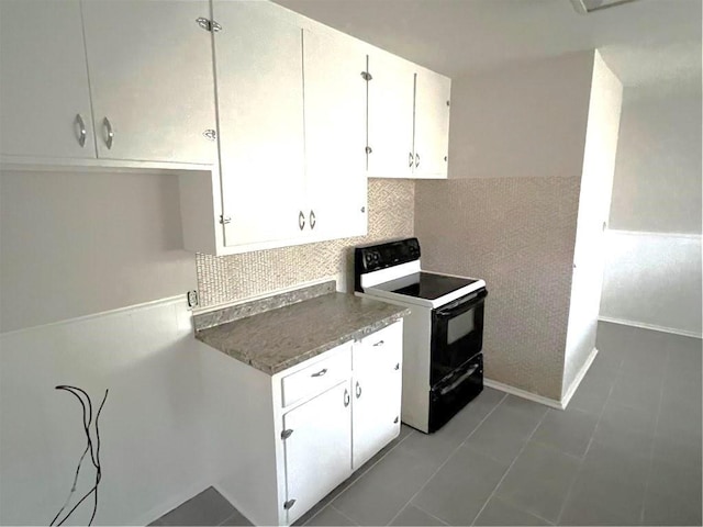 kitchen with white cabinetry, black electric range oven, and decorative backsplash