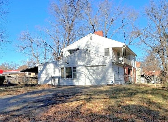 view of side of property featuring a garage and a balcony