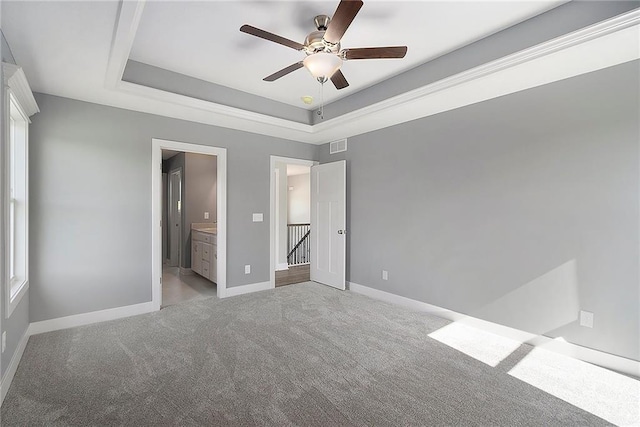 12414 Adam St, Excelsior Springs, MO 64024 - unfurnished bedroom with carpet, baseboards, a raised ceiling, ensuite bath, and a ceiling fan