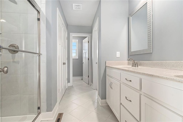 12414 Adam St, Excelsior Springs, MO 64024 - bathroom with a stall shower, tile patterned floors, double vanity, and baseboards