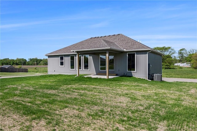 12414 Adam St, Excelsior Springs, MO 64024 - rear view of property featuring a lawn, a patio area, central AC unit, and a shingled roof