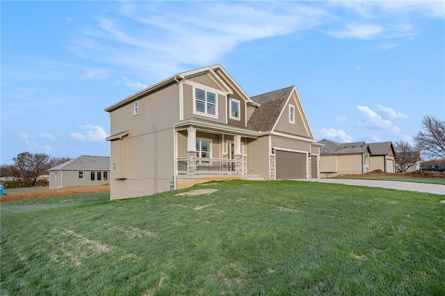 view of front of home with covered porch, a front yard, and a garage