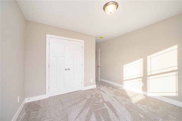 unfurnished bedroom with light carpet and a closet