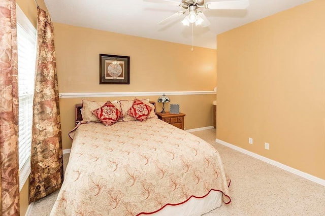 bedroom with ceiling fan, light colored carpet, and baseboards