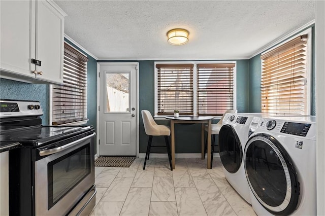 laundry room featuring washing machine and dryer, a textured ceiling, and ornamental molding