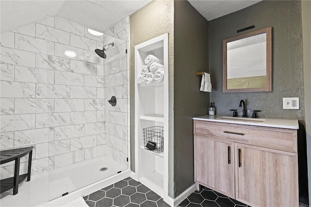 bathroom featuring tile patterned floors, tiled shower, and vanity