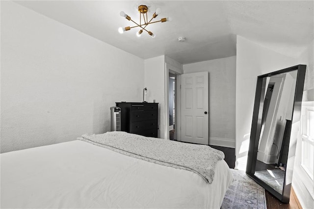 bedroom featuring dark wood-type flooring and an inviting chandelier