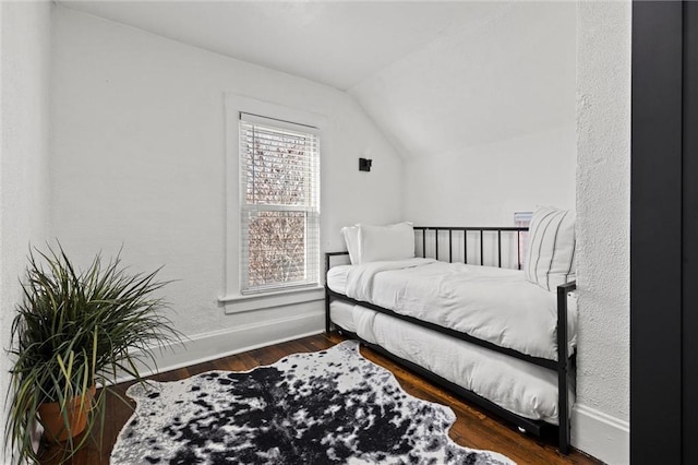 bedroom featuring dark hardwood / wood-style flooring and vaulted ceiling