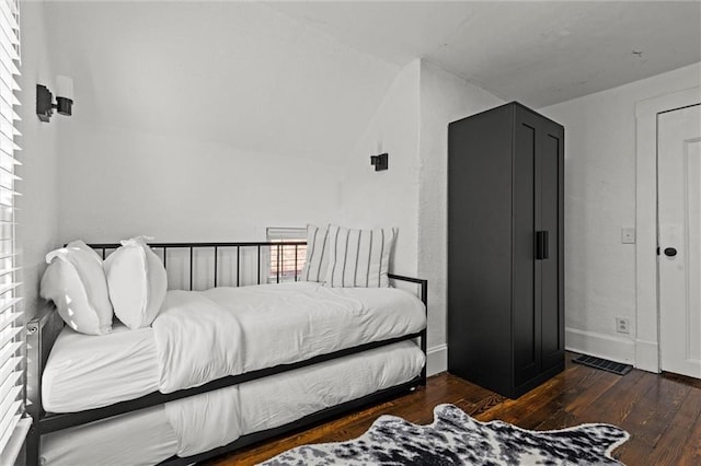 bedroom with lofted ceiling and dark wood-type flooring