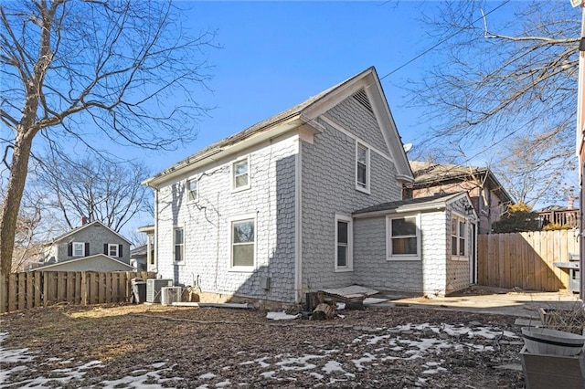 snow covered rear of property with central AC