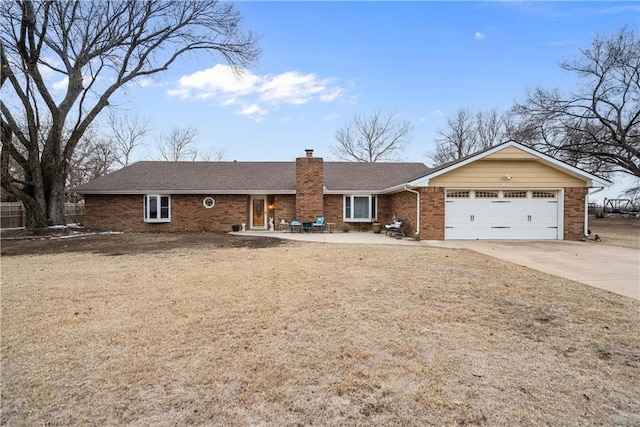 ranch-style home featuring brick siding, concrete driveway, a chimney, an attached garage, and a front yard