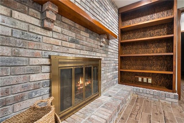 interior details featuring a brick fireplace and wood finished floors