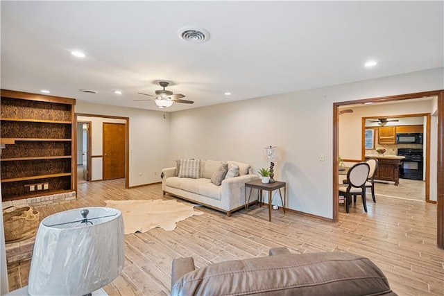 living area featuring light wood finished floors, ceiling fan, visible vents, and recessed lighting