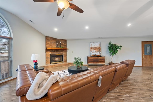 living room featuring lofted ceiling, a fireplace, recessed lighting, and wood finished floors