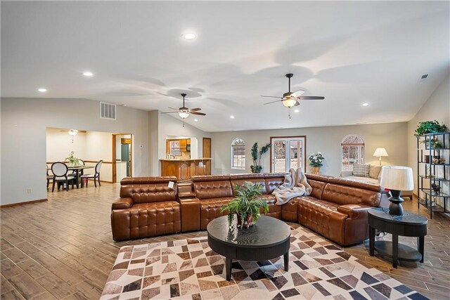 living room featuring light wood finished floors, visible vents, vaulted ceiling, and recessed lighting