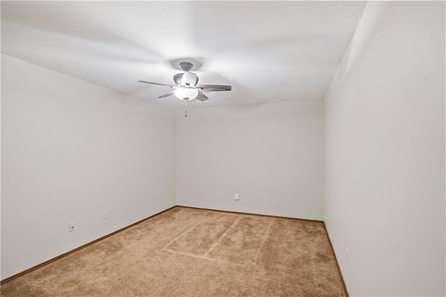 spare room featuring ceiling fan, baseboards, and light colored carpet