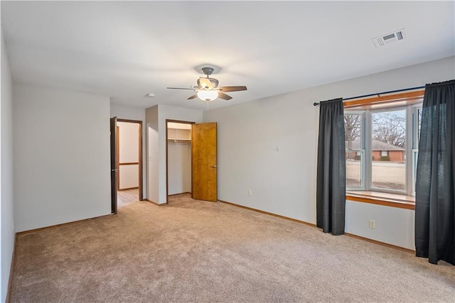 unfurnished bedroom with baseboards, visible vents, a closet, and light colored carpet