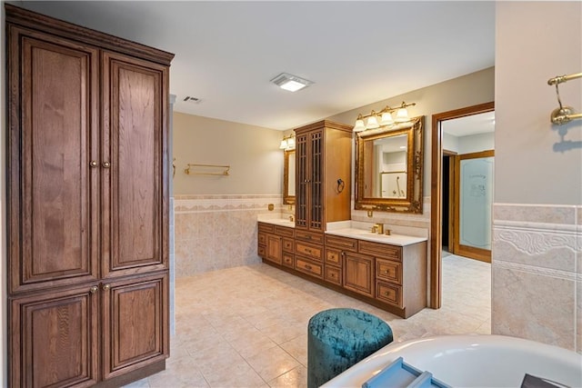 full bathroom featuring a wainscoted wall, tile walls, visible vents, vanity, and tile patterned floors