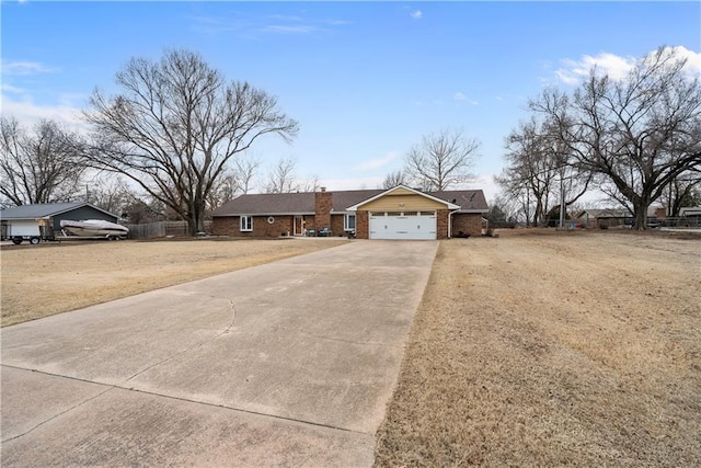 ranch-style home featuring concrete driveway, an attached garage, fence, a front lawn, and brick siding