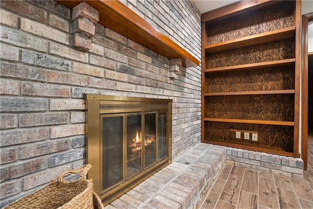 room details featuring wood finished floors and a brick fireplace
