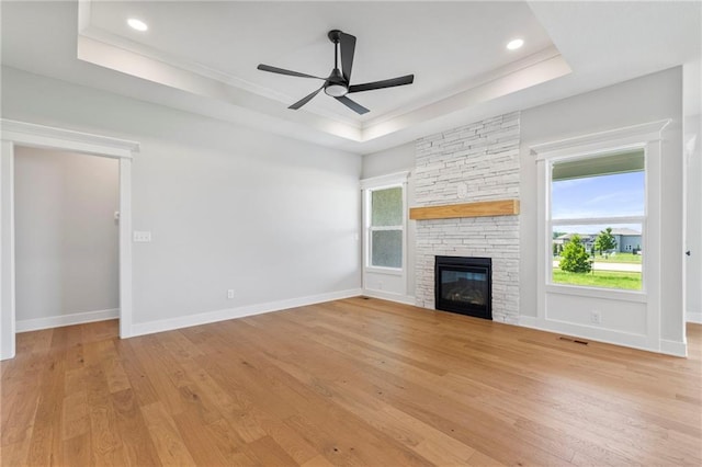 17151 W 168th Pl, Olathe, KS 66062 - unfurnished living room featuring a tray ceiling, light wood-style flooring, a ceiling fan, a fireplace, and recessed lighting