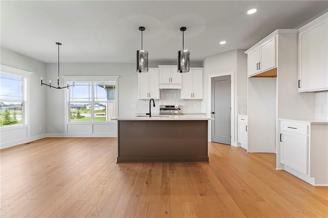 17151 W 168th Pl, Olathe, KS 66062 - kitchen with light countertops, light wood-type flooring, white cabinets, tasteful backsplash, and recessed lighting