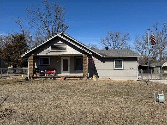 view of front facade with a front lawn, fence, and brick siding