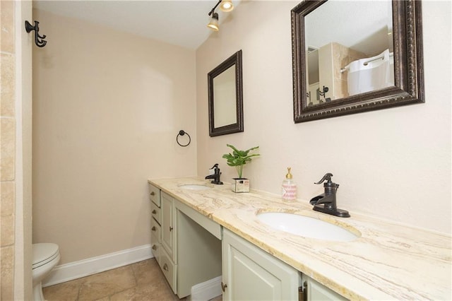 bathroom with toilet, vanity, and tile patterned flooring