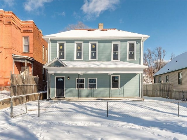 traditional style home featuring a chimney and fence