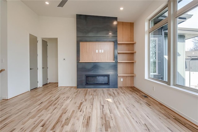 unfurnished living room featuring visible vents, a large fireplace, baseboards, recessed lighting, and wood finished floors