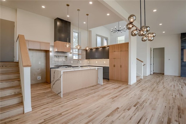 kitchen featuring light wood finished floors, range hood, and modern cabinets