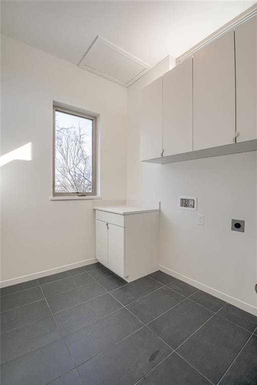 clothes washing area featuring baseboards, dark tile patterned floors, washer hookup, cabinet space, and hookup for an electric dryer