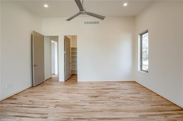 unfurnished bedroom featuring recessed lighting, light wood-type flooring, visible vents, and a spacious closet